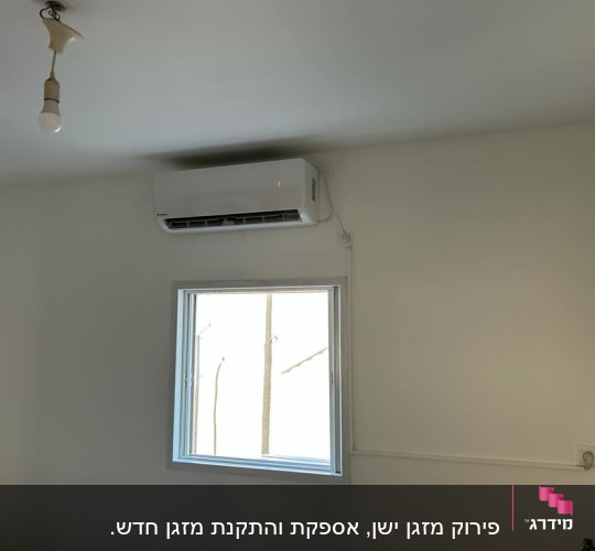 מזגן מותקן על קיר מעל חלון בחדר